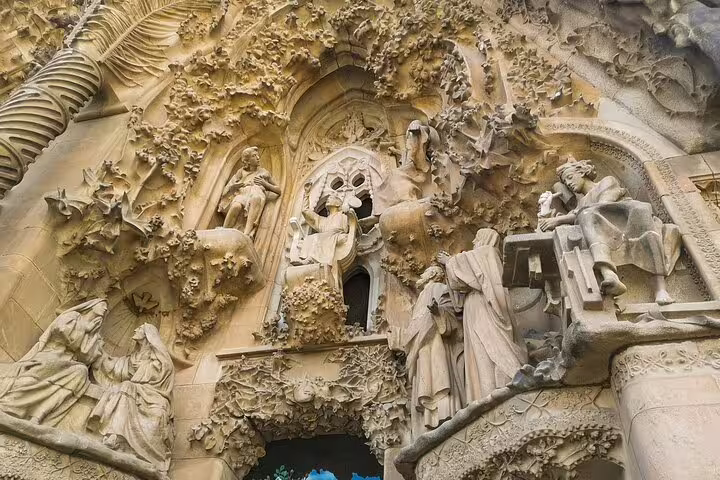 Intricate stone carvings adorn the Sagrada Familia facade, showcasing Gaudi's architectural genius on a 2-day tour of Barcelona and Montserrat.