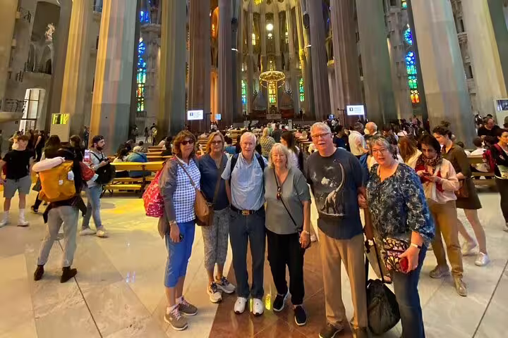 Tourists exploring the stunning interior of Sagrada Familia, highlighting the vibrant stained-glass windows in Barcelona.