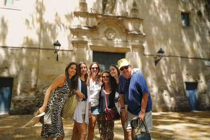 Group of tourists enjoying a sunny day outside a historic site on the Private Religious Tour of Sagrada Familia, Romans & Jewish Quarter.
