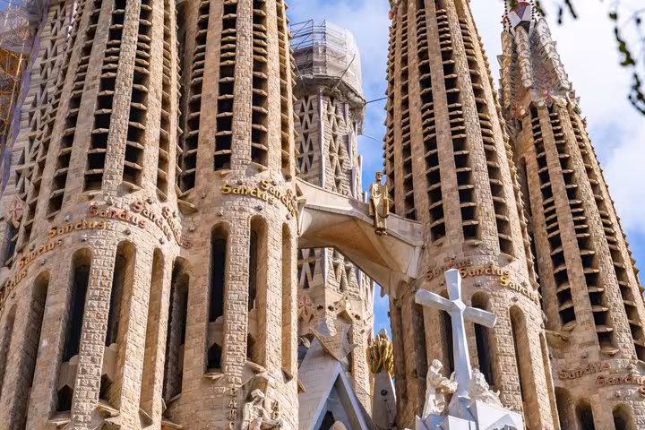 Intricate stone towers and cross sculptures of Barcelona's Sagrada Familia on a guided architecture walking tour