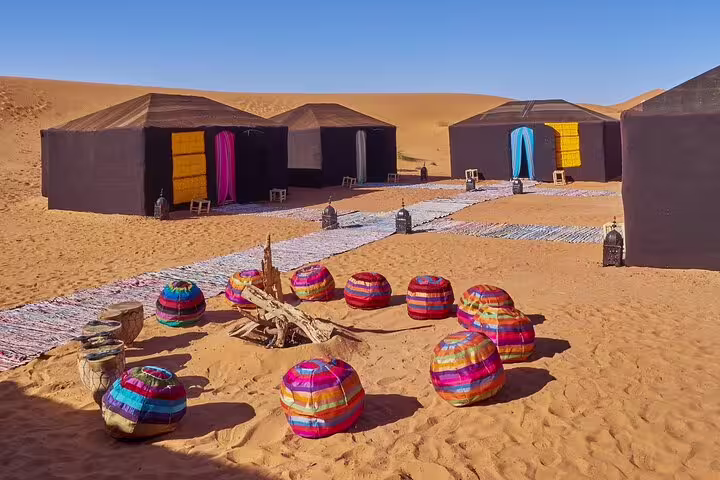 Luxury Sahara desert camp with colorful poufs and tents in Merzouga, on 9-day Tangier to Marrakech tour