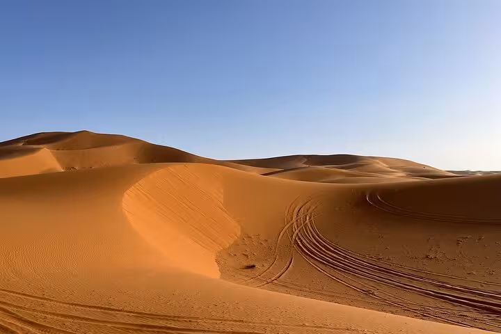Scenic view of undulating Sahara dunes under a clear blue sky on a 2-day luxury desert tour from Fes.