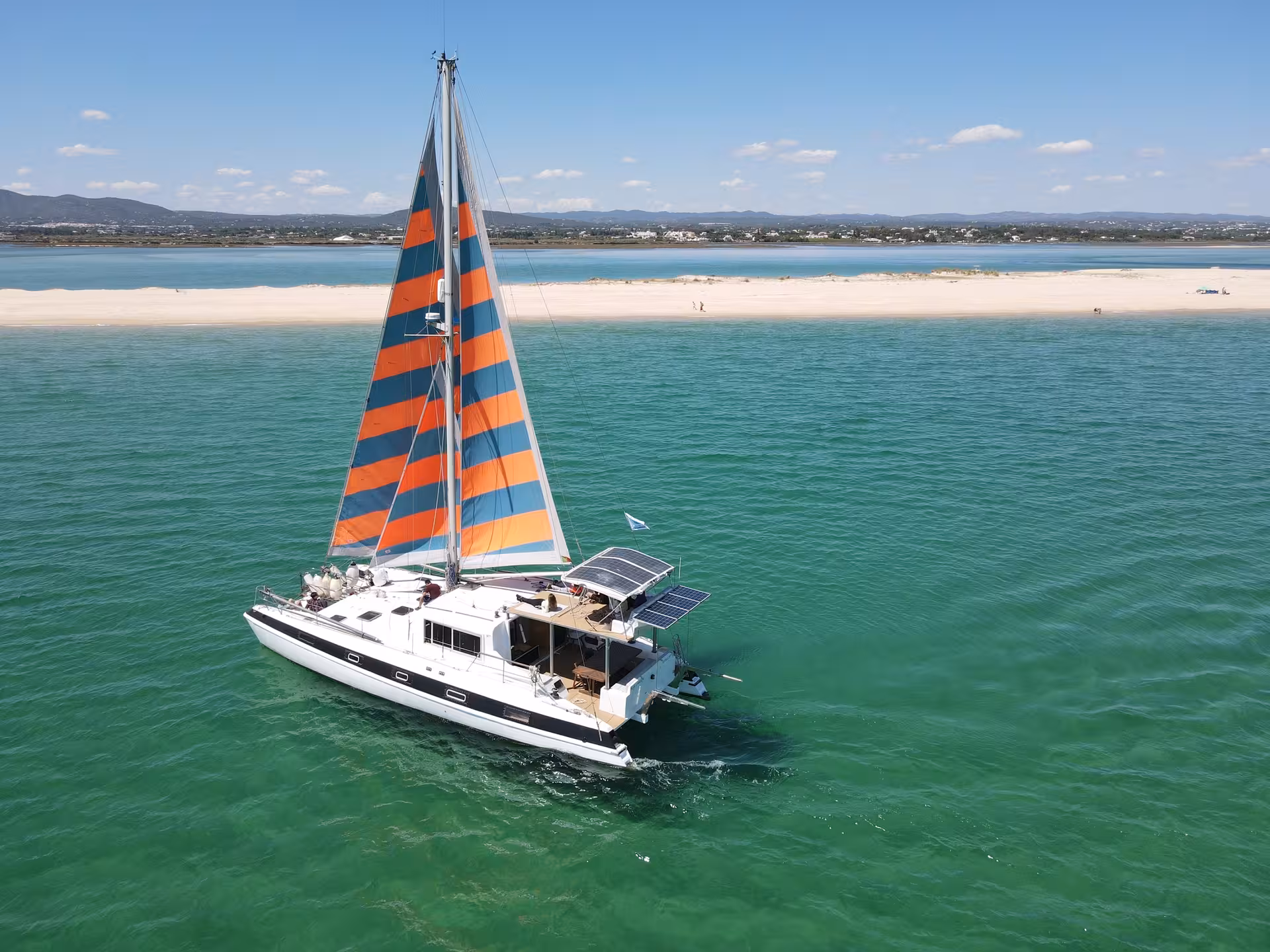 Aerial view of sail catamaran cruising turquoise Blue Lagoon waters on a half-day boat tour with swim stop