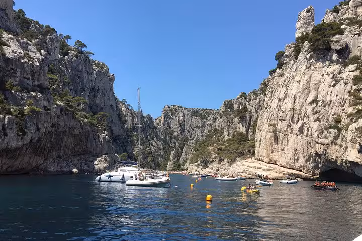 Sailboat anchored in Calanques National Park near Marseille, turquoise cove framed by limestone cliffs