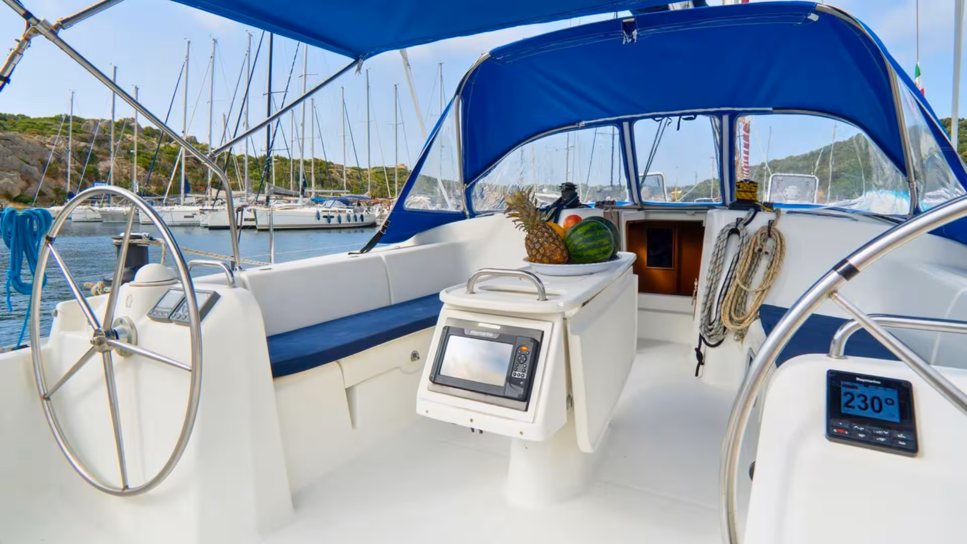 Inside view of sailboat cockpit with fresh fruits, ideal for Santa Teresa di Gallura to Corsica voyage.