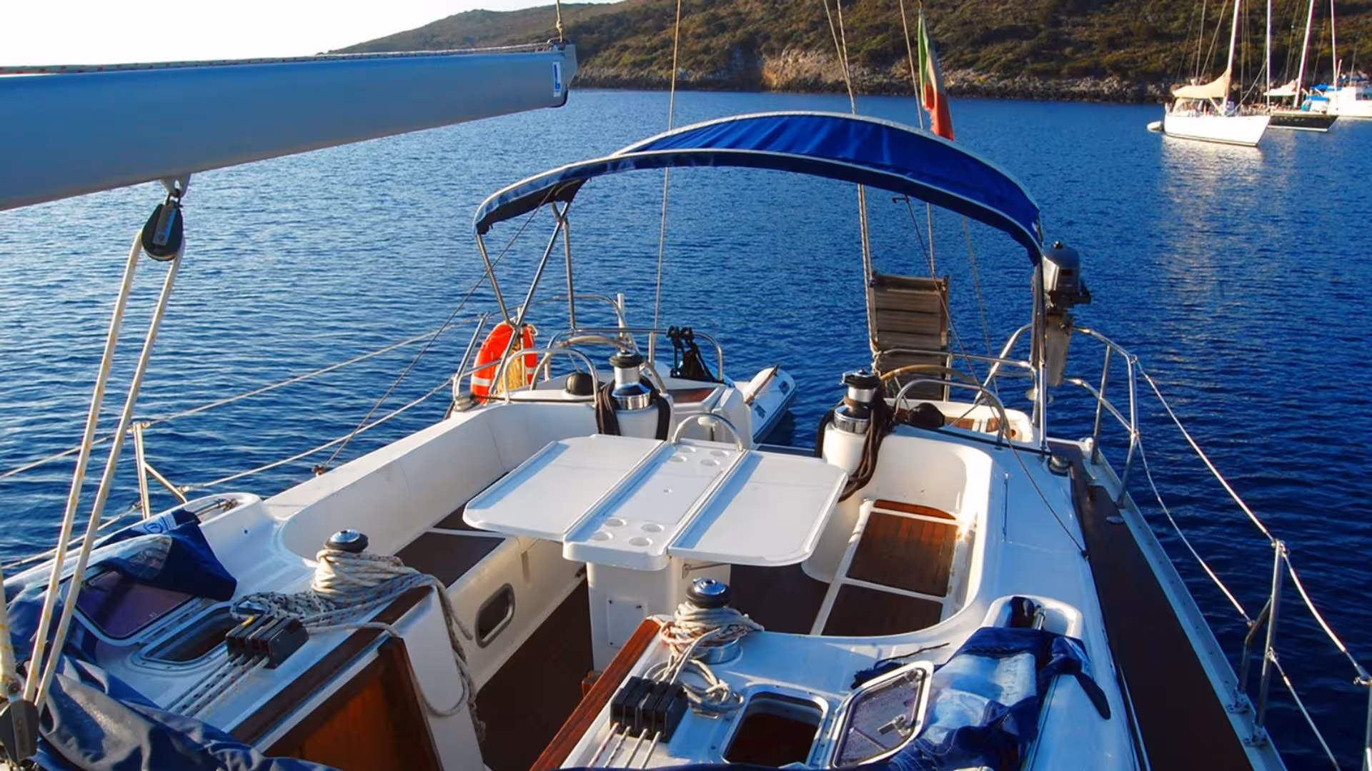 Spacious sailboat deck with seating and table, ideal for exploring the pristine Gulf of Orosei waters from Arbatax.