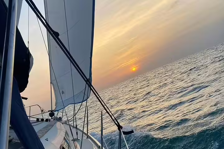 Sailboat cruising on Mediterranean Sea at sunset during private day trip to Ibiza and Formentera, offering a serene maritime escape.