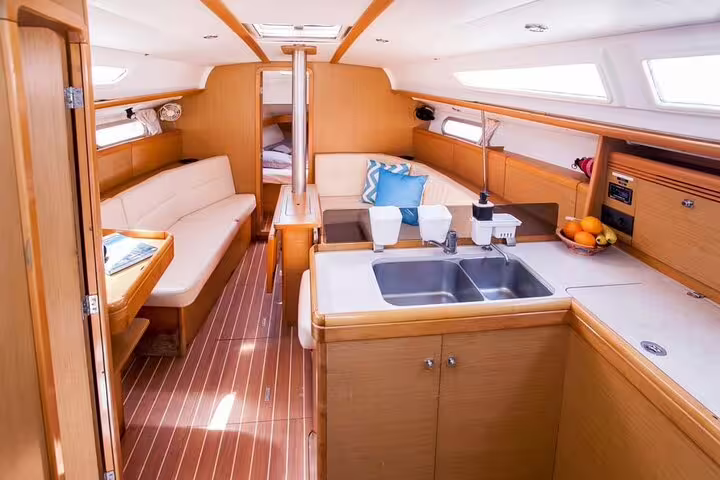 Luxurious interior of a sailboat featuring a cozy lounge and kitchen area, ideal for a private day trip to Ibiza and Formentera.