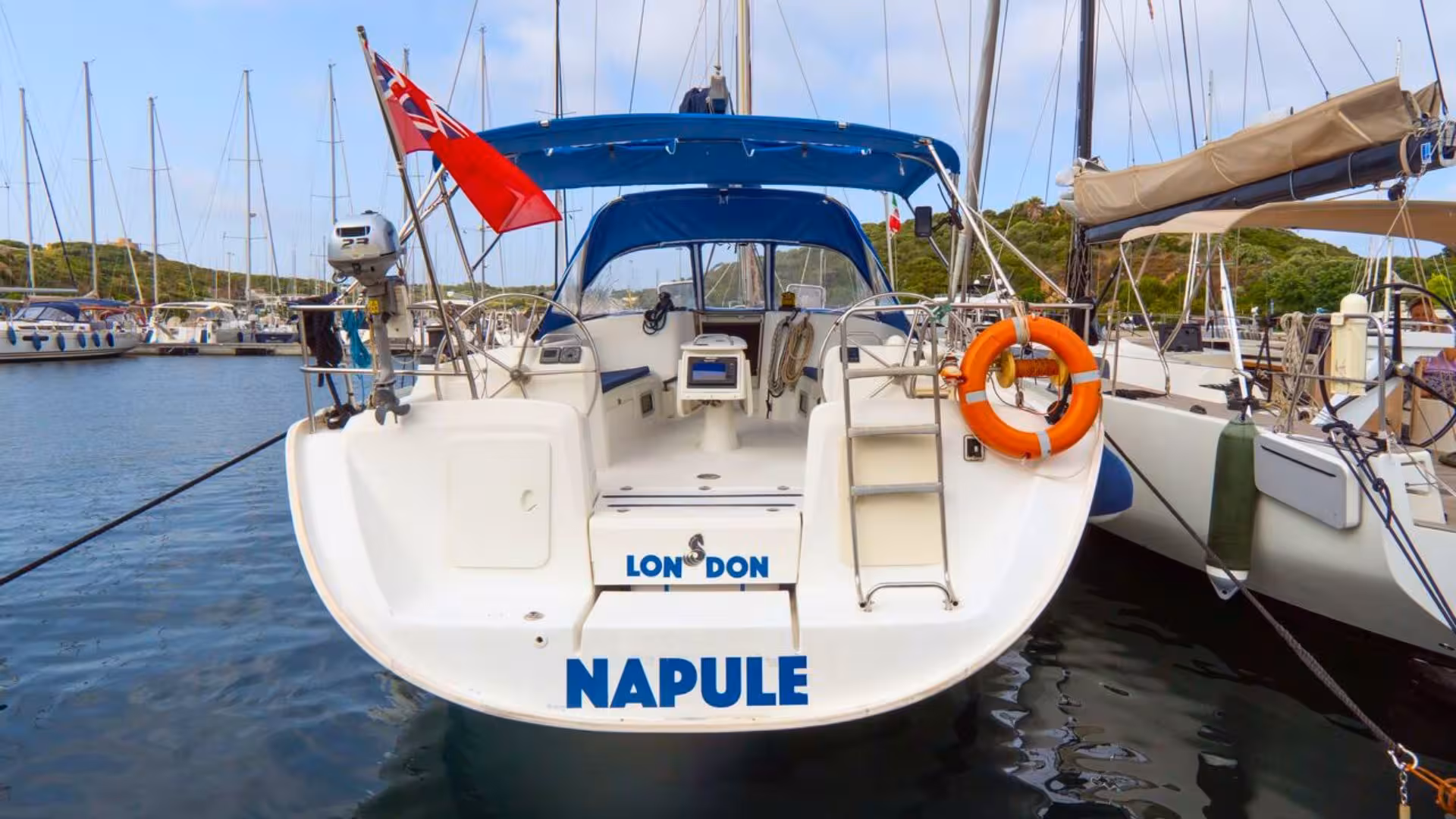 Sailing boat docked in Santa Teresa di Gallura, ready for La Maddalena Archipelago tour, with clear blue skies.