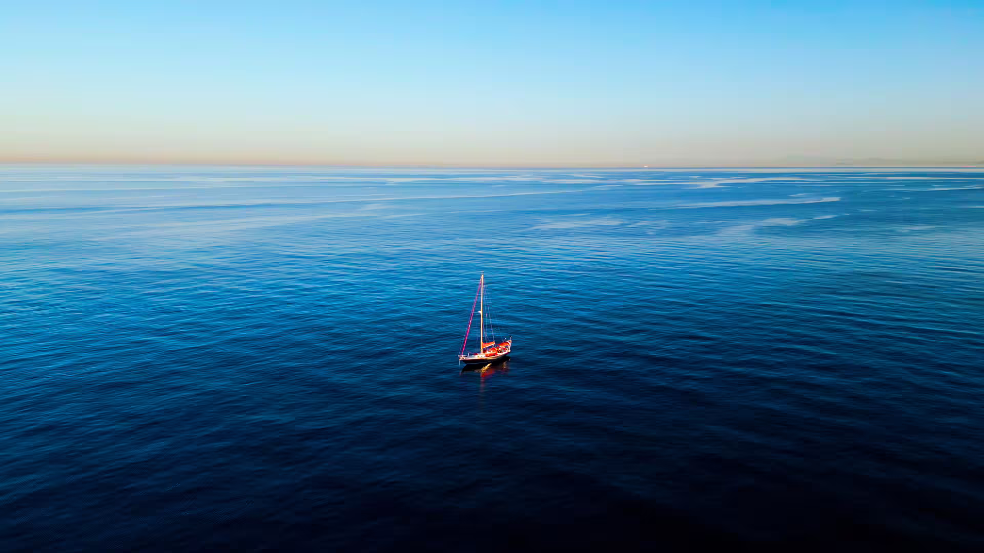 A lone sailboat on the serene blue waters, capturing the tranquility of a minicruise from Sotogrande to Puerto de la Duquesa.
