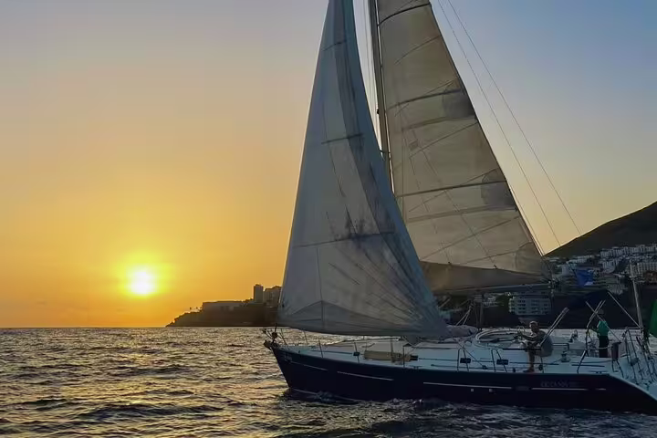 Sailboat gliding on Madeira's ocean at sunset during a private cruise, perfect for sunrise, sunset, and moonlight sailing experiences.