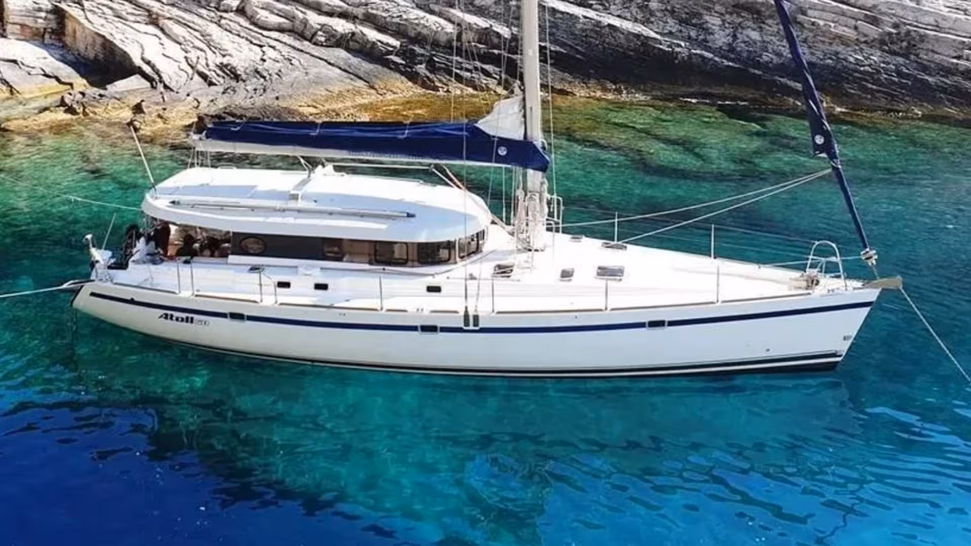 Sailboat anchored in the clear turquoise waters of Tavolara Marine Area, highlighting a serene and picturesque excursion.