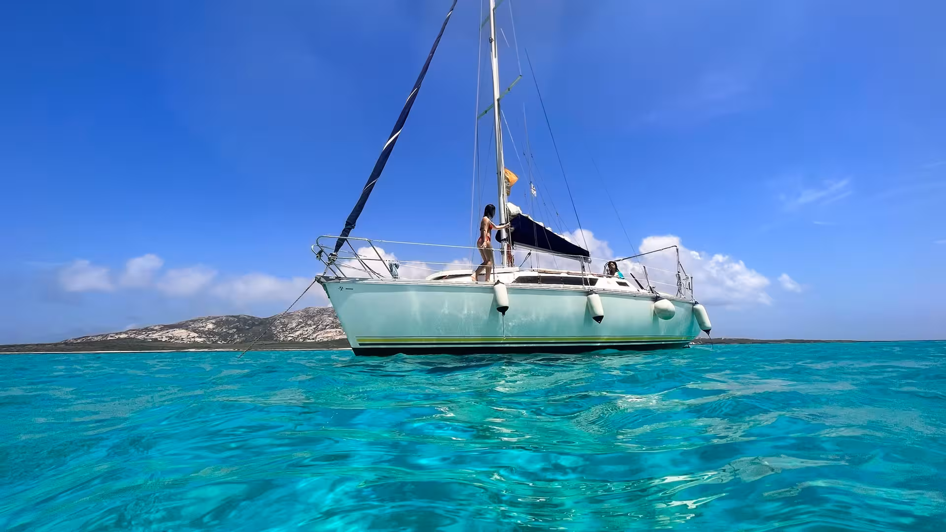 Sailboat anchored in Asinara's turquoise sea, offering a serene and picturesque sailing experience from Stintino.