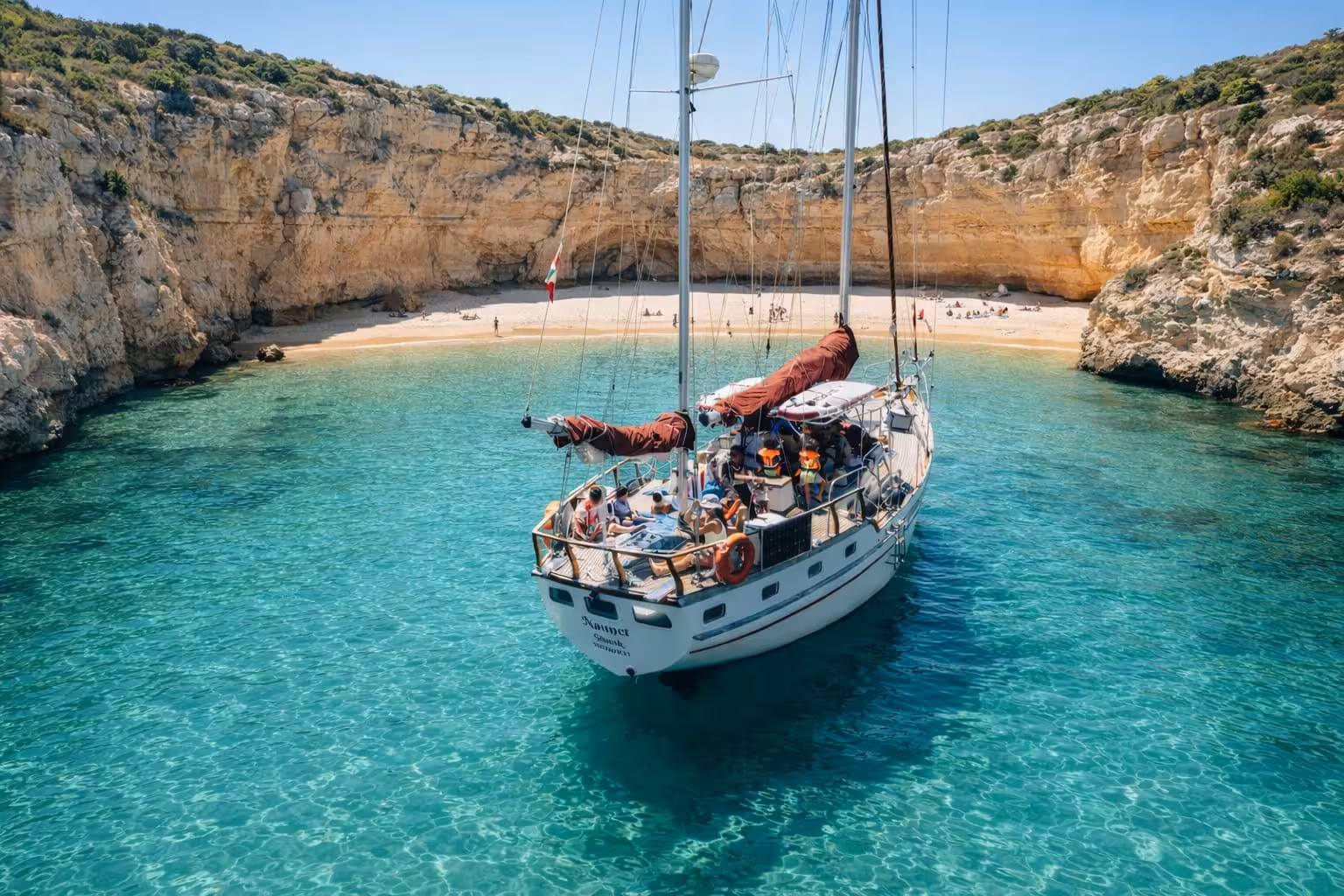 Sailboat anchored in a stunning turquoise cove near Portimao on a scenic Algarve coastal sailing tour