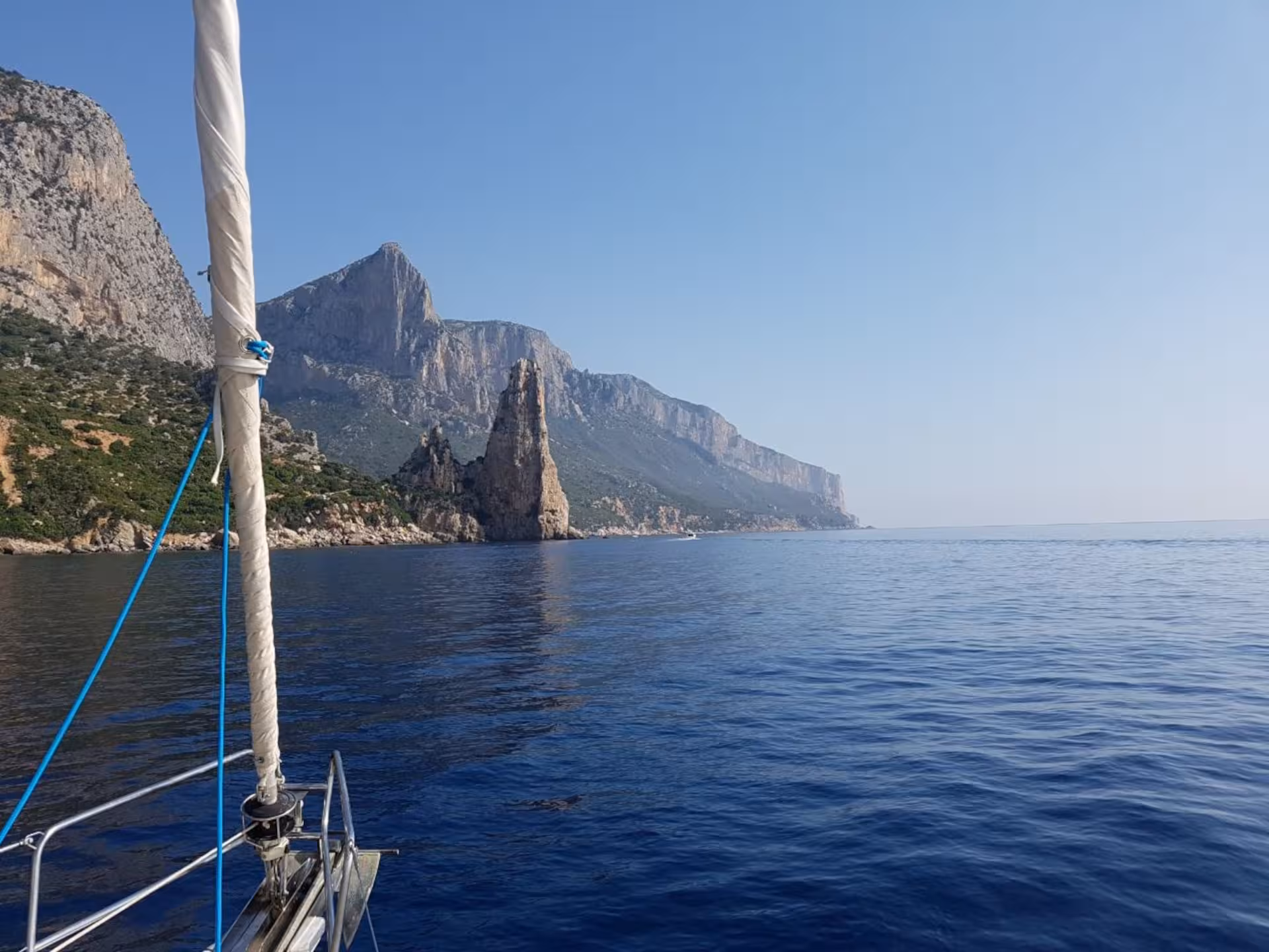 Sailing boat in the Gulf of Orosei with stunning rocky cliffs and clear blue sea near Arbatax.