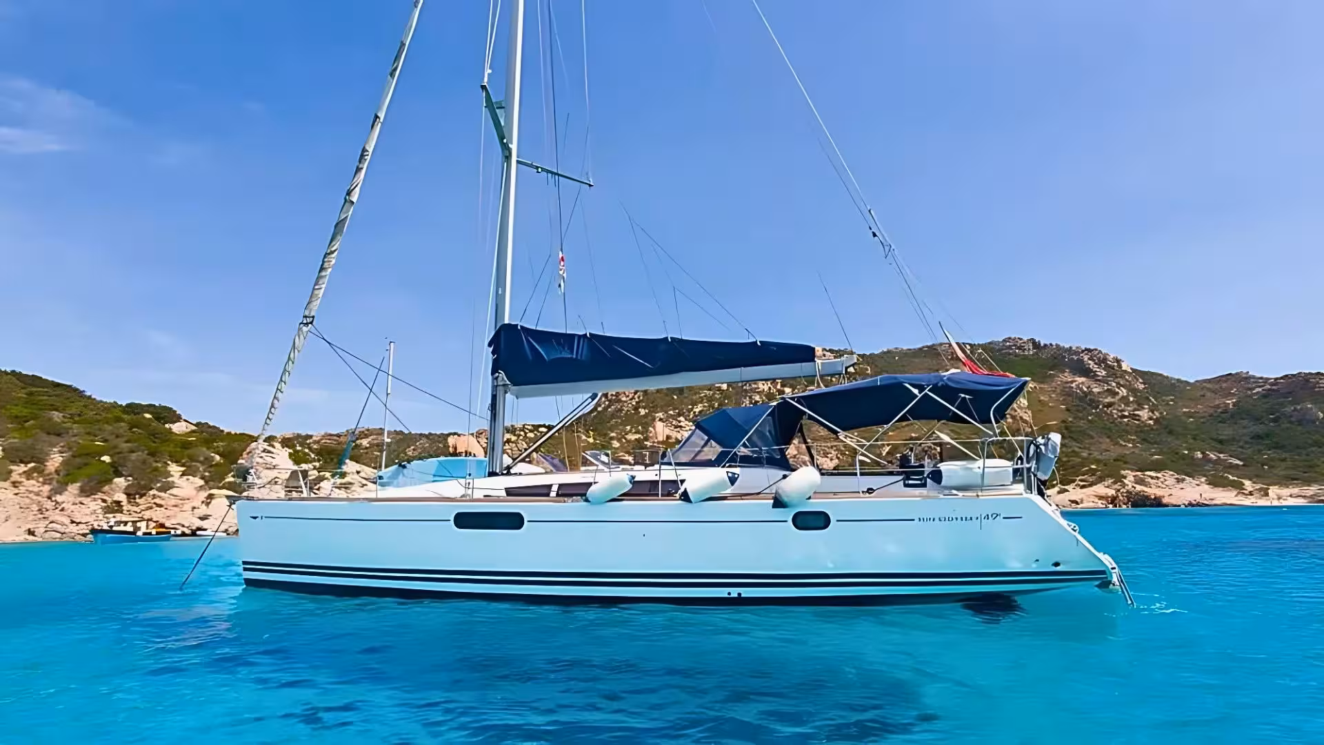 Sailing boat anchored in crystal-clear waters of La Maddalena Archipelago, perfect for Cannigione boat tours.