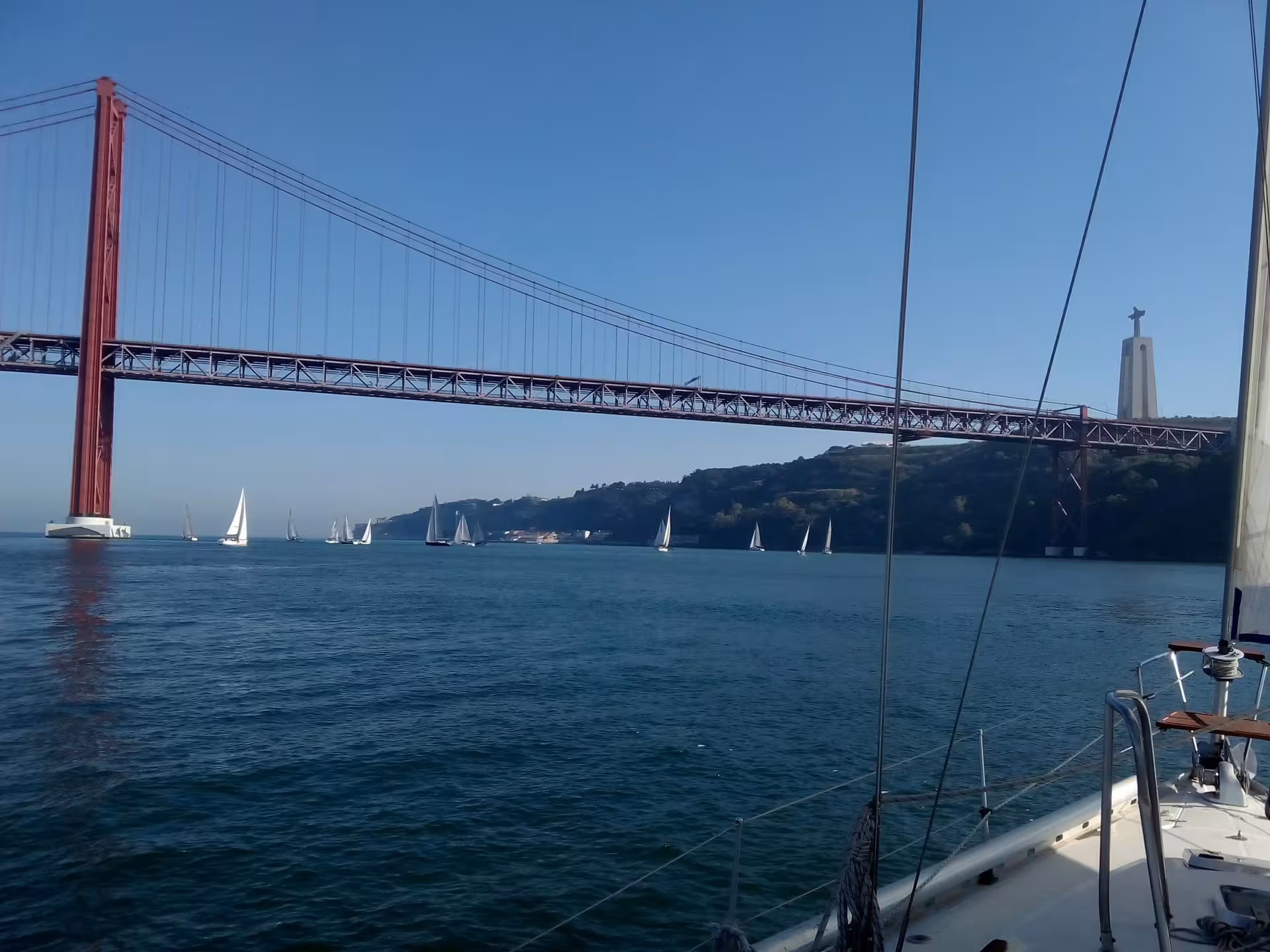 Sailing under 25 de Abril Bridge with Cristo Rei in Lisbon on the Tagus, Cultural Sail Tour Lisbon