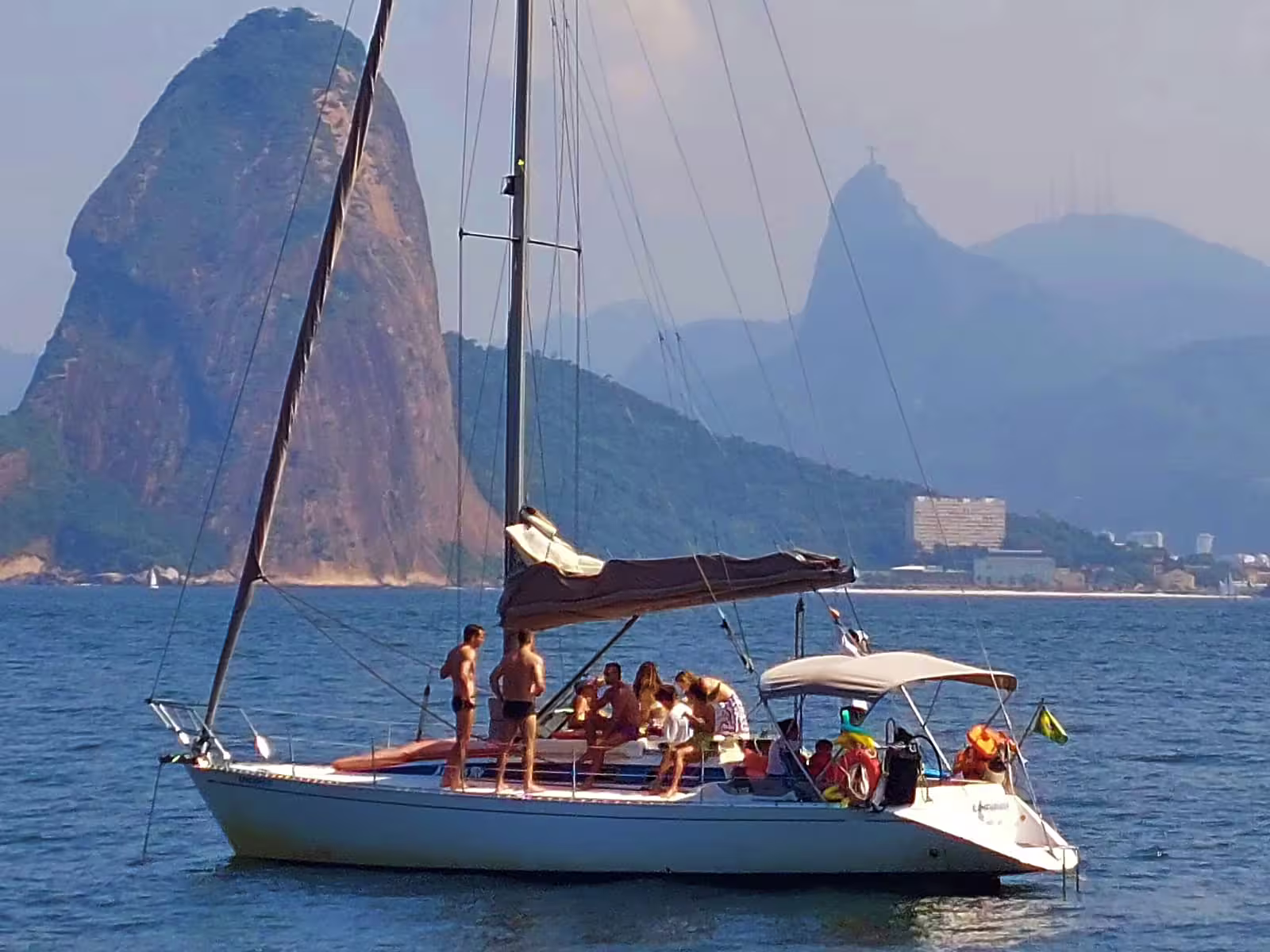 Sailing yacht with tourists enjoying views of iconic coastal rock formations.