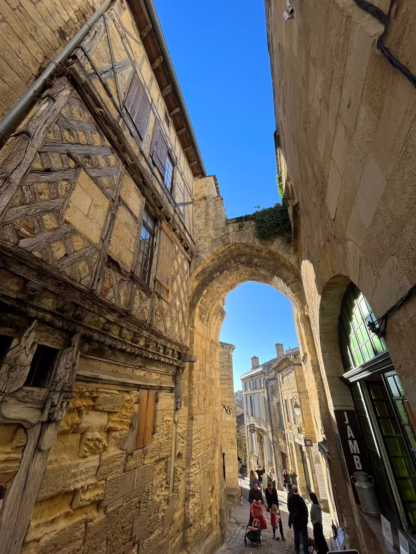 Historic archway and medieval street in Saint-Émilion on small group walking tour en route to cave tasting