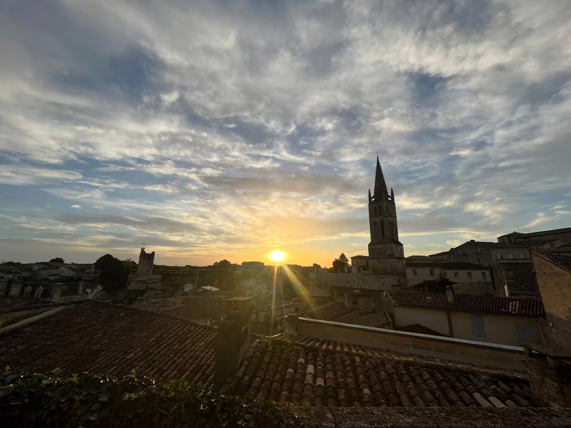Sunset over Saint-Emilion rooftops and church spire, scenic stop on small-group walking tour and cave tasting