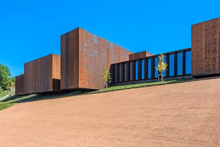Modern Corten steel building with rusty facade and glass windows on a hillside in Saint-Etienne