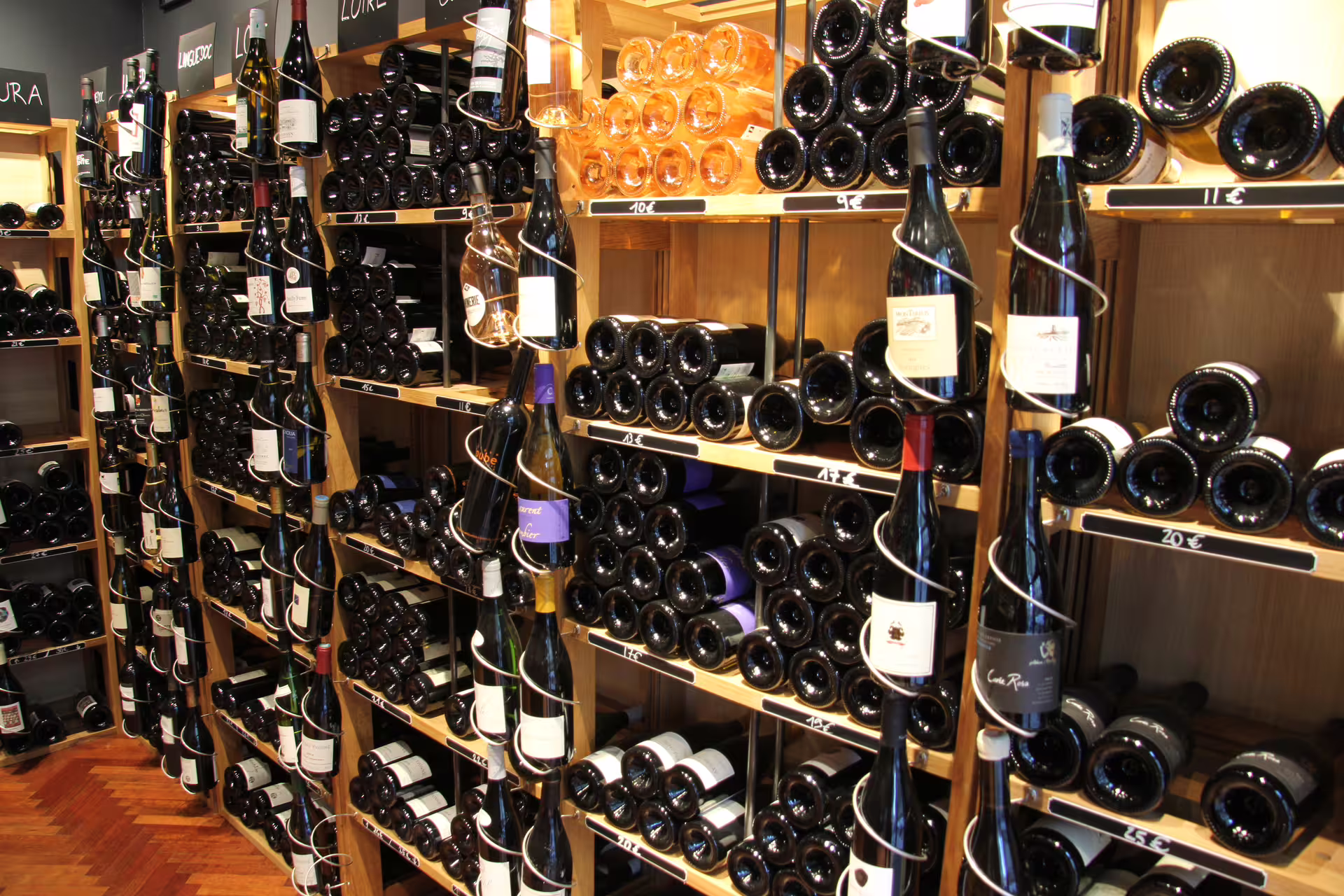 Wine bottles displayed on wooden shelves in a Paris wine shop in Saint-Germain
