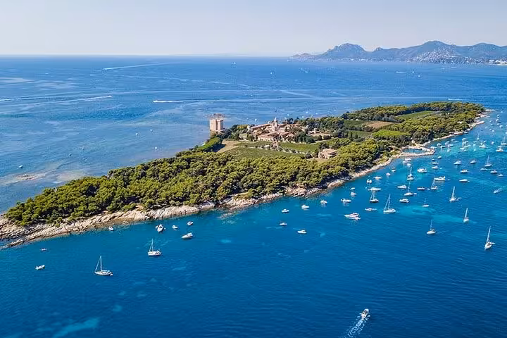 Aerial view of Saint-Honorat Island with sailboats anchored in turquoise Mediterranean waters near Cannes
