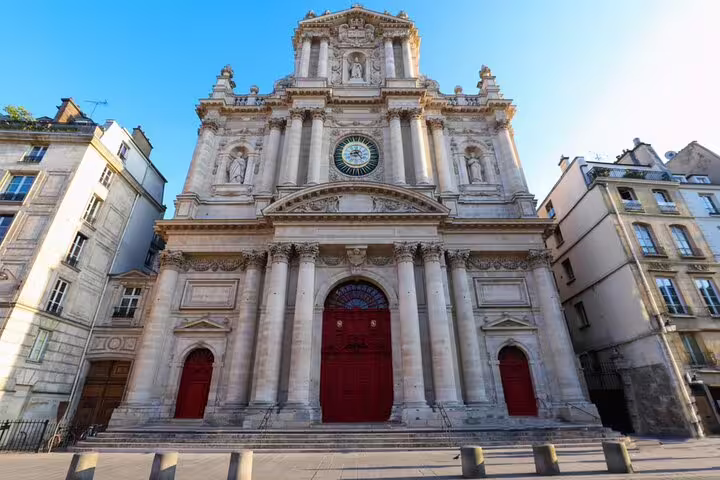 Baroque facade of Saint-Paul church with red doors and ornate clock in Le Marais, Paris