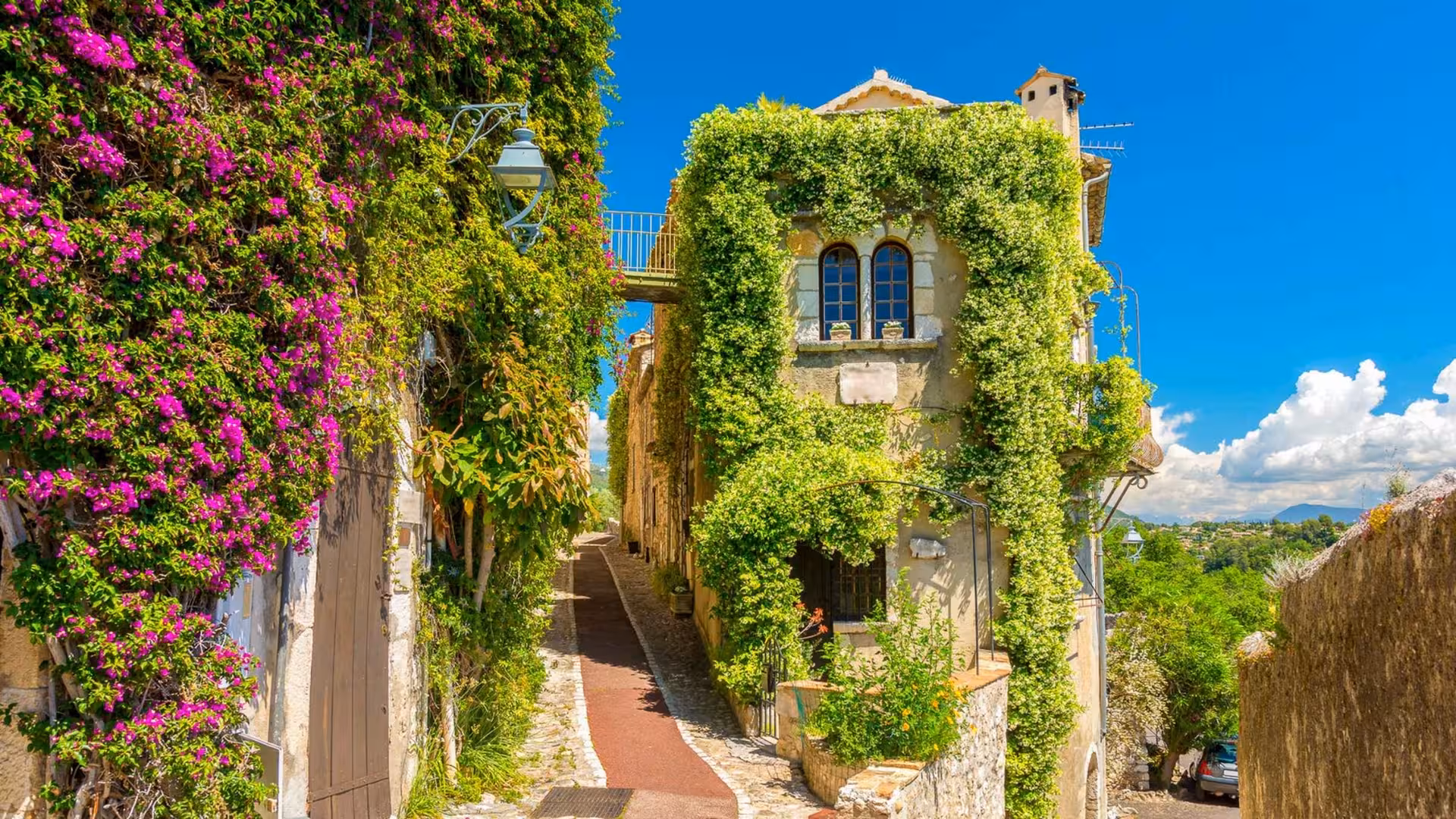 Ivy-covered stone buildings lining a narrow cobblestone street in Saint-Paul-de-Vence, Provence, France