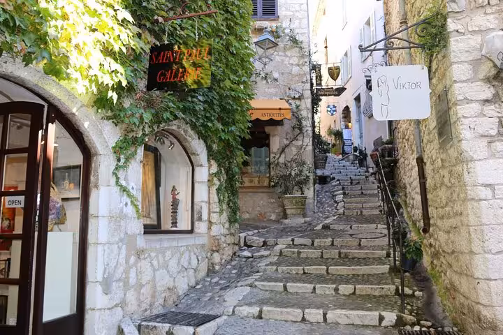 Cobblestone alley with art galleries and stone steps in a medieval Provençal village, French Riviera