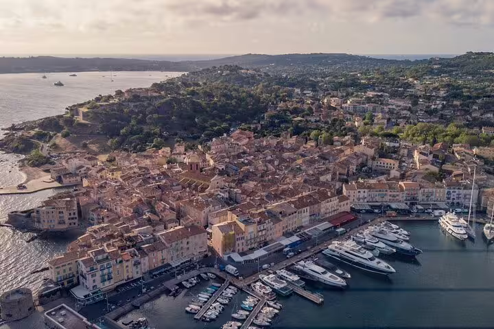 Aerial view of Saint-Tropez harbor with luxury yachts and terracotta rooftops on the French Riviera