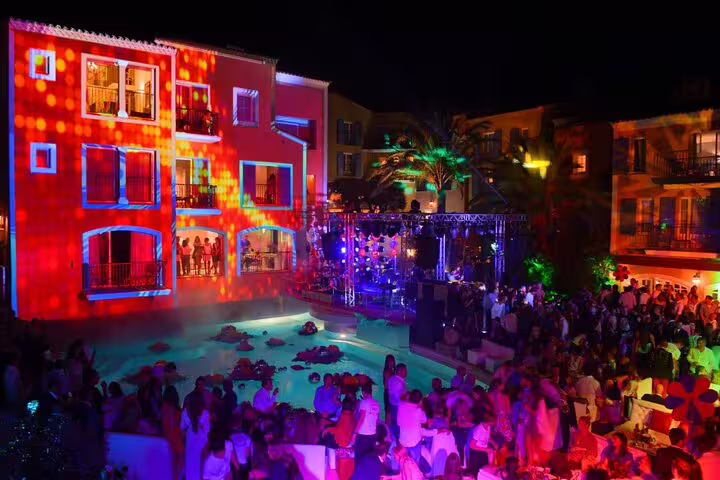 Vibrant nighttime pool party with colorful lights at a Saint-Tropez venue