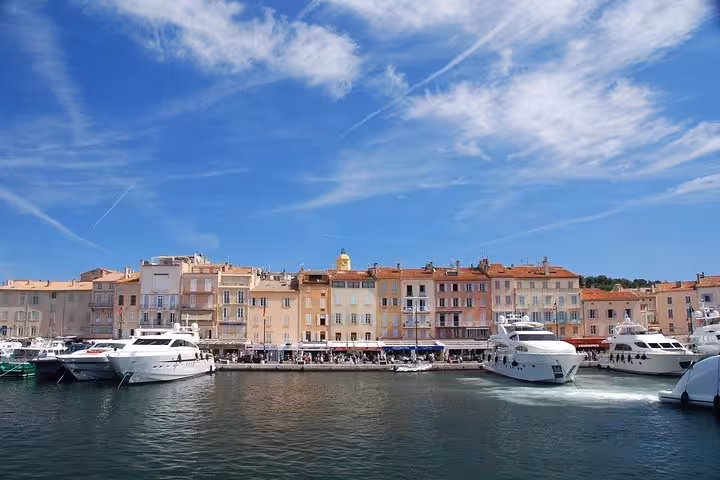 Saint-Tropez old port harbor with colorful buildings and luxury yachts on a sunny day