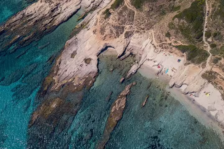 Aerial view of rocky coastline with turquoise water and sandy beach near Saint Tropez, French Riviera
