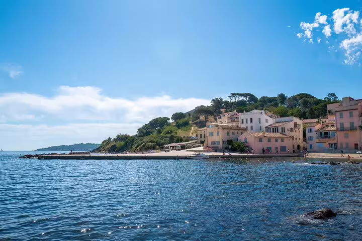 Colorful waterfront buildings and pier of Saint-Tropez village on the French Riviera under blue sky