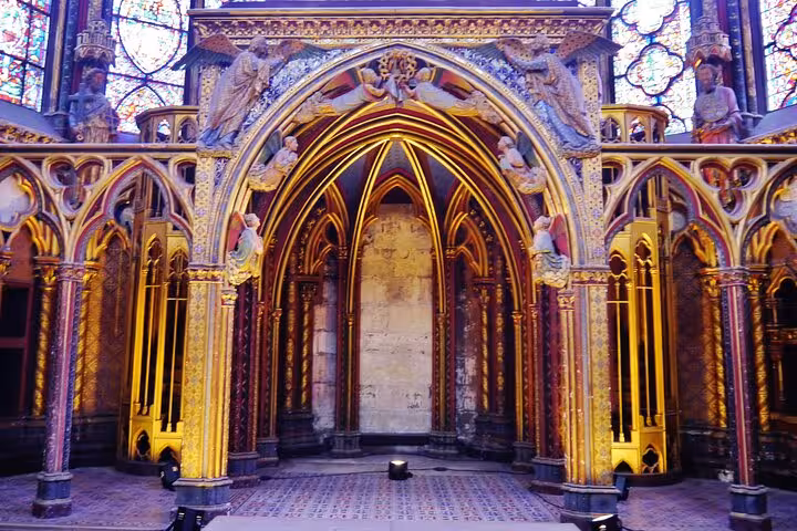 Ornate golden Gothic arches and stained glass windows inside Sainte-Chapelle Paris