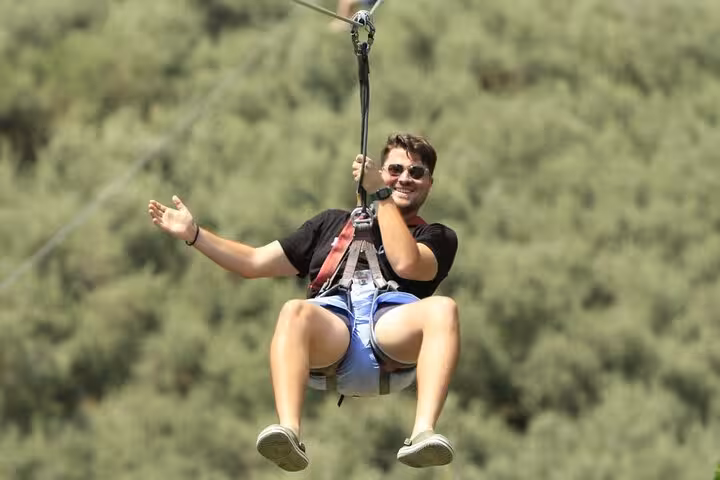 Adventurous zipline experience in Saklıkent Canyon with lush green backdrop on a guided tour from Fethiye.