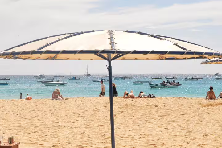 Beach umbrella and turquoise sea in Sal Island, relaxing view on private airport transfer route to Murdeira