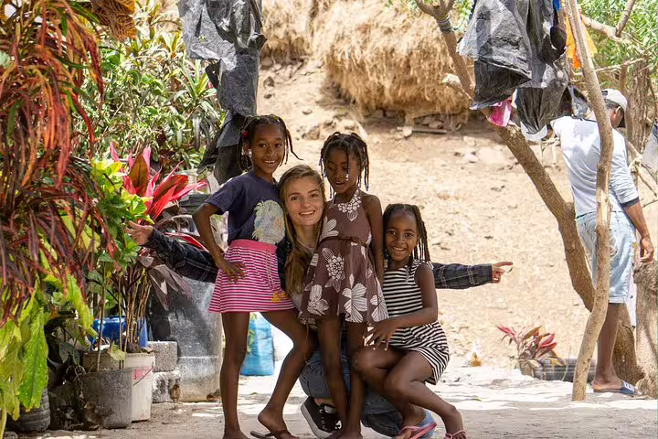 Group of children posing in a vibrant garden on Sal Island, capturing local culture and warmth during a stress-free holiday.