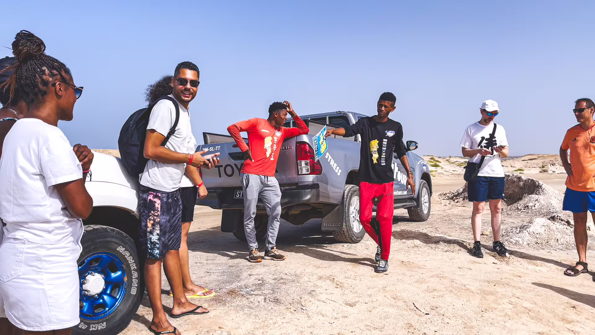 Guests meet guide beside 4x4 pickup on Sal Island full-day tour, Cape Verde, exploring desert landscapes