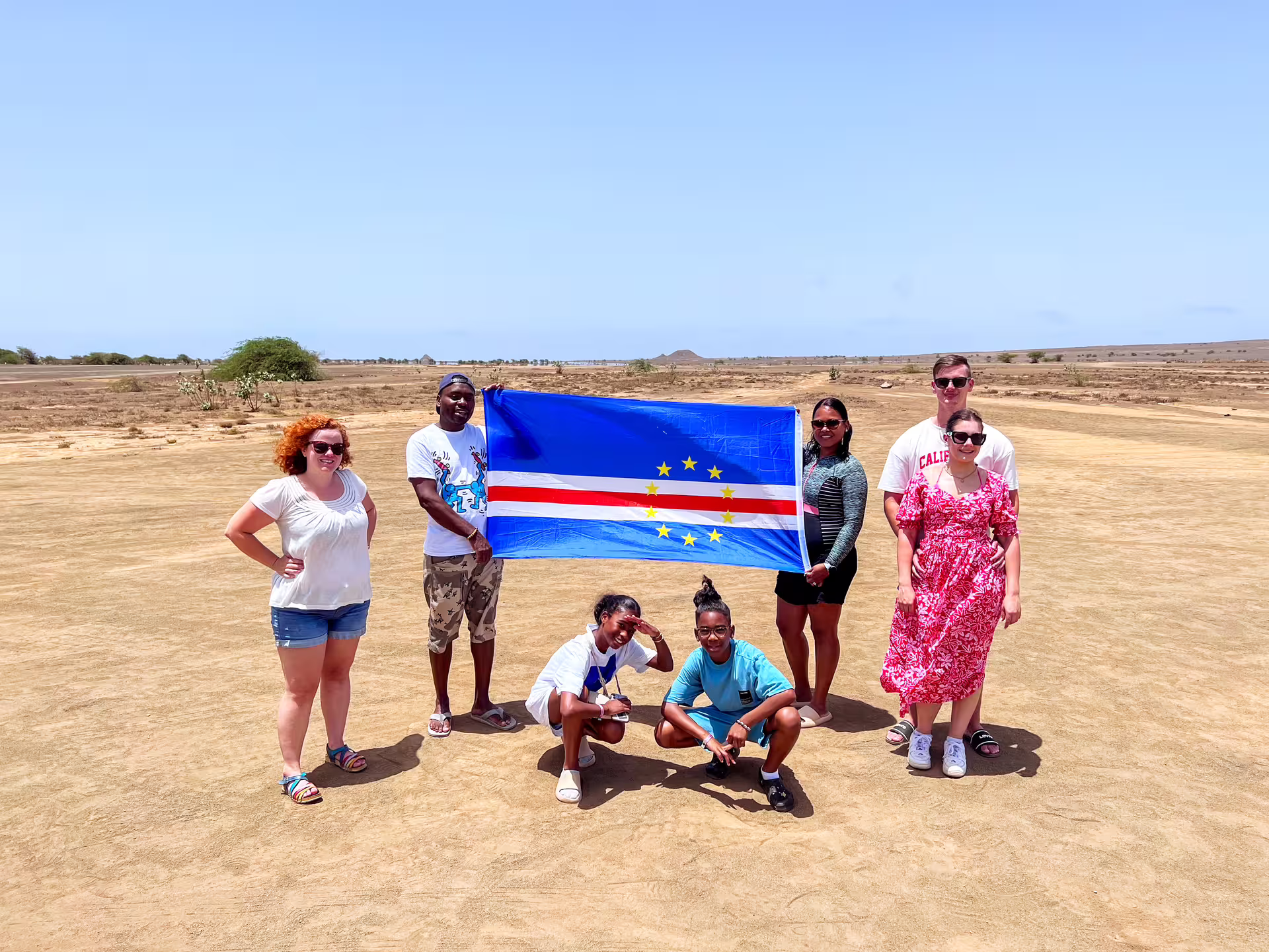 Group holding Cape Verde flag on Sal Island, enjoying a guided full-day highlights tour.