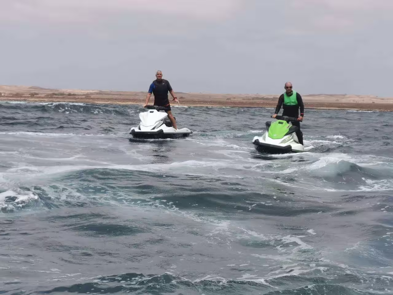 Two people on jet skis navigate the choppy waters off Sal Island, perfect for an exciting adventure tour.