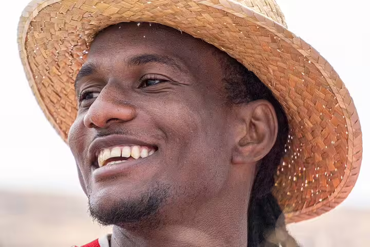 Smiling person in a straw hat enjoying a sunny day on Sal Island, perfect for a relaxing no-stress holiday package.
