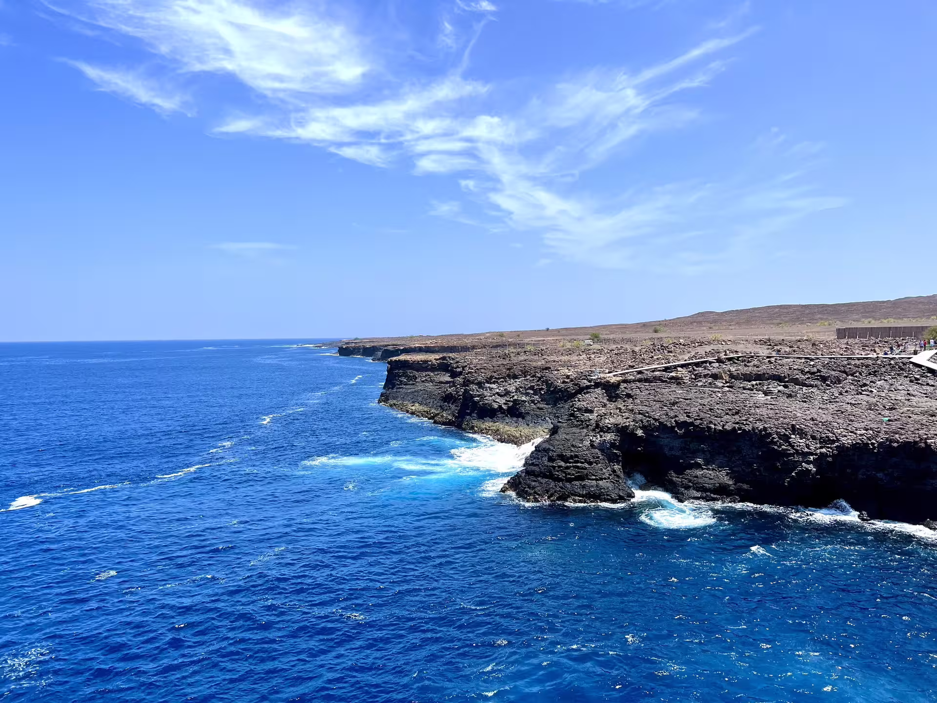 Rocky cliffs and vibrant blue ocean under sunny skies on Sal Island's scenic coastline tour.