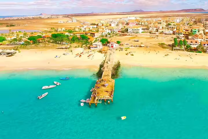 Aerial view of Santa Maria pier on Sal Island, showcasing pristine beaches and vibrant town life in a serene setting.