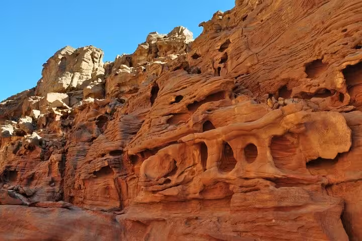 Wind-carved red sandstone cliffs in Salama Canyon, a scenic stop on Dahab Jeep safari from Sharm El Sheikh
