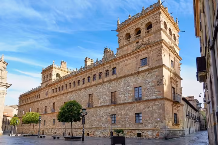 Ornate Renaissance palace facade with decorative stonework and tower in Salamanca city center