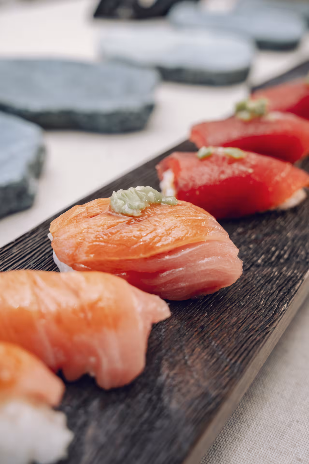 Salmon and tuna nigiri with wasabi on a wooden board, showcasing skills taught in a Sushi Masterclass