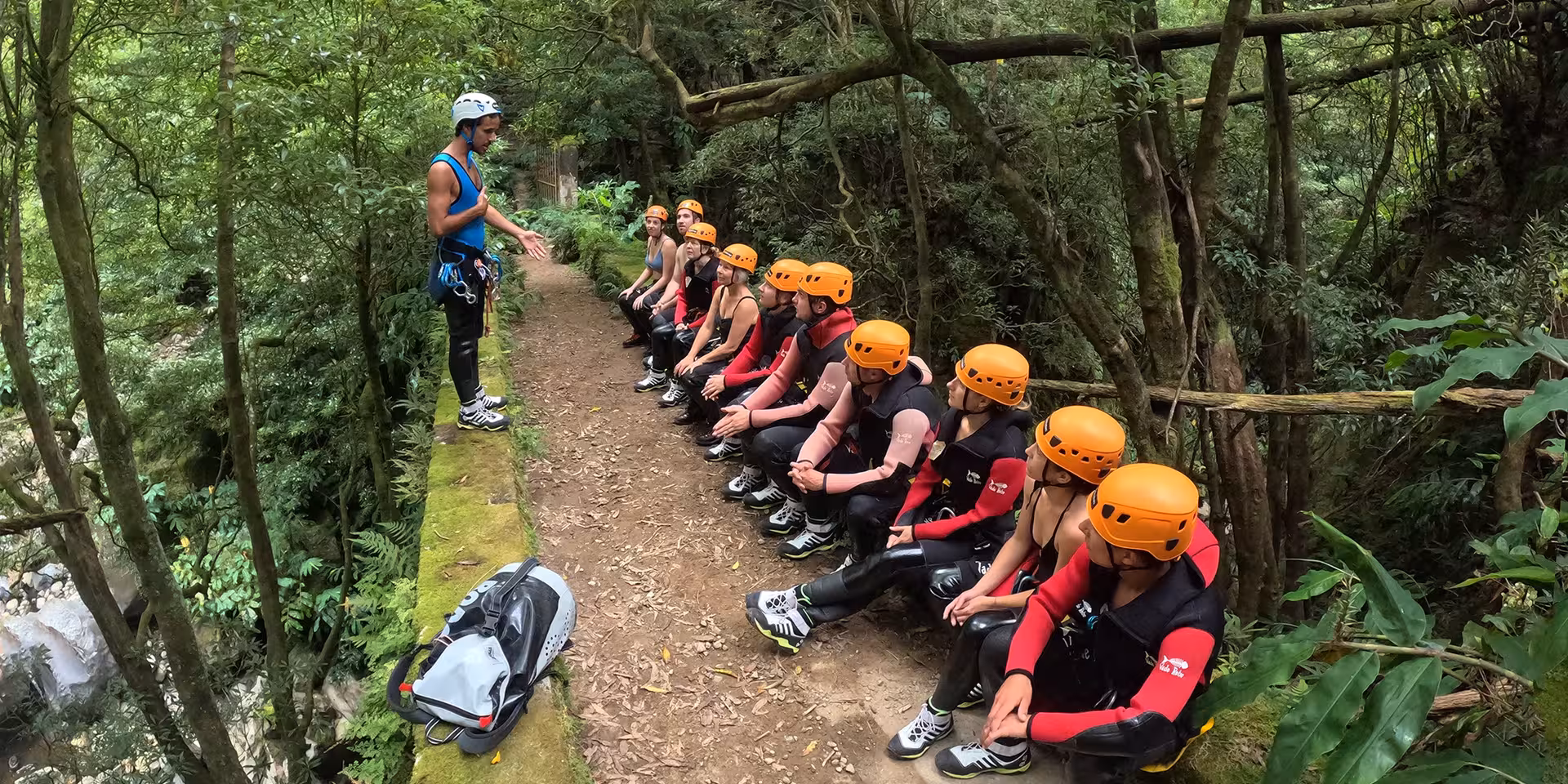 Safety briefing before Salto do Cabrito canyoning in São Miguel, Azores, group in helmets and wetsuits