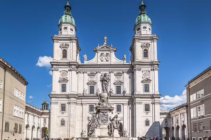 Salzburg Cathedral baroque facade with twin green towers and Mary's Column in Domplatz square